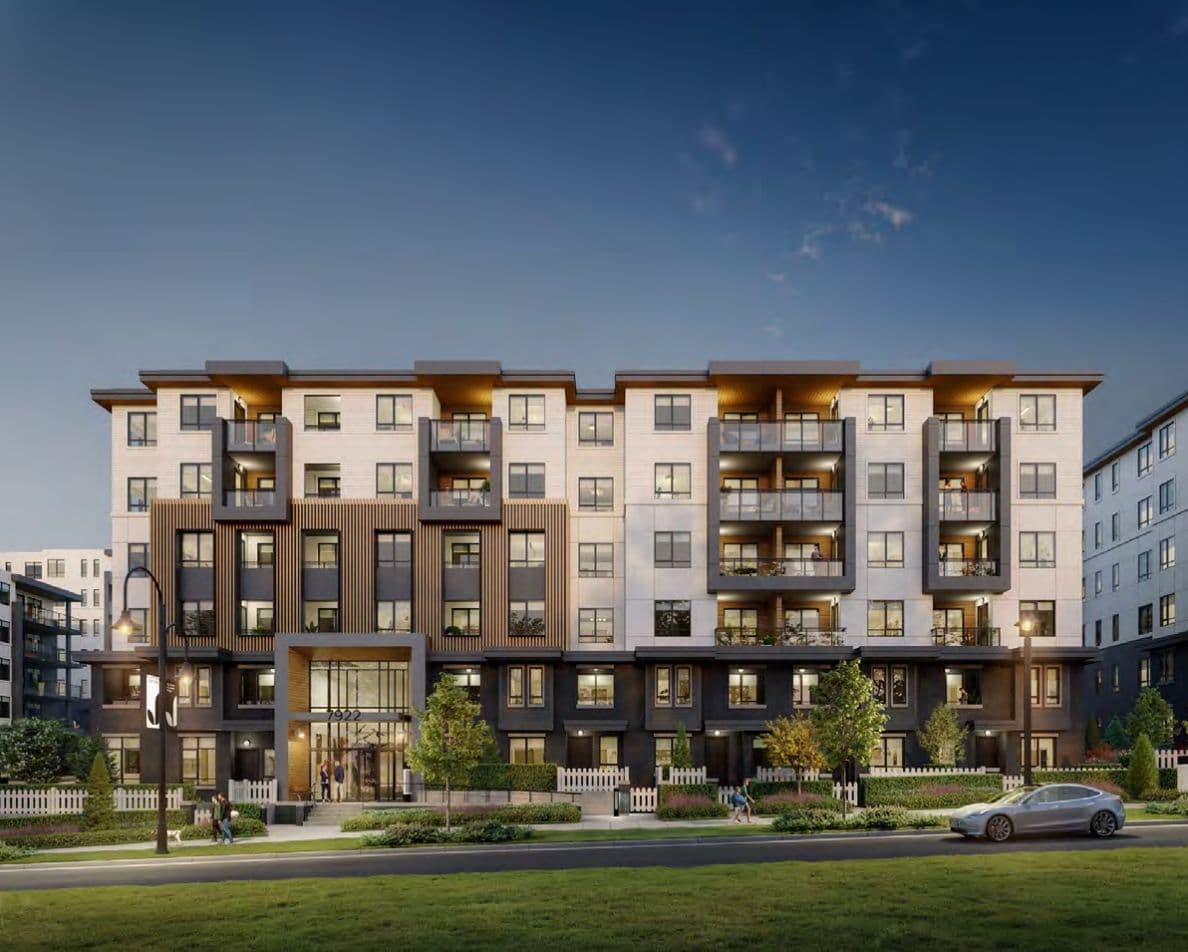 Jericho – Twilight street-level view of a mid-rise condo building with balconies, ground-floor townhome units, and an illuminated entrance.