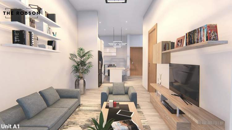 The Robson – Rendered living room in Unit A1 with a grey sofa and armchair, a media wall with shelving and a wall-mounted TV, opening to a kitchen island in the background.
