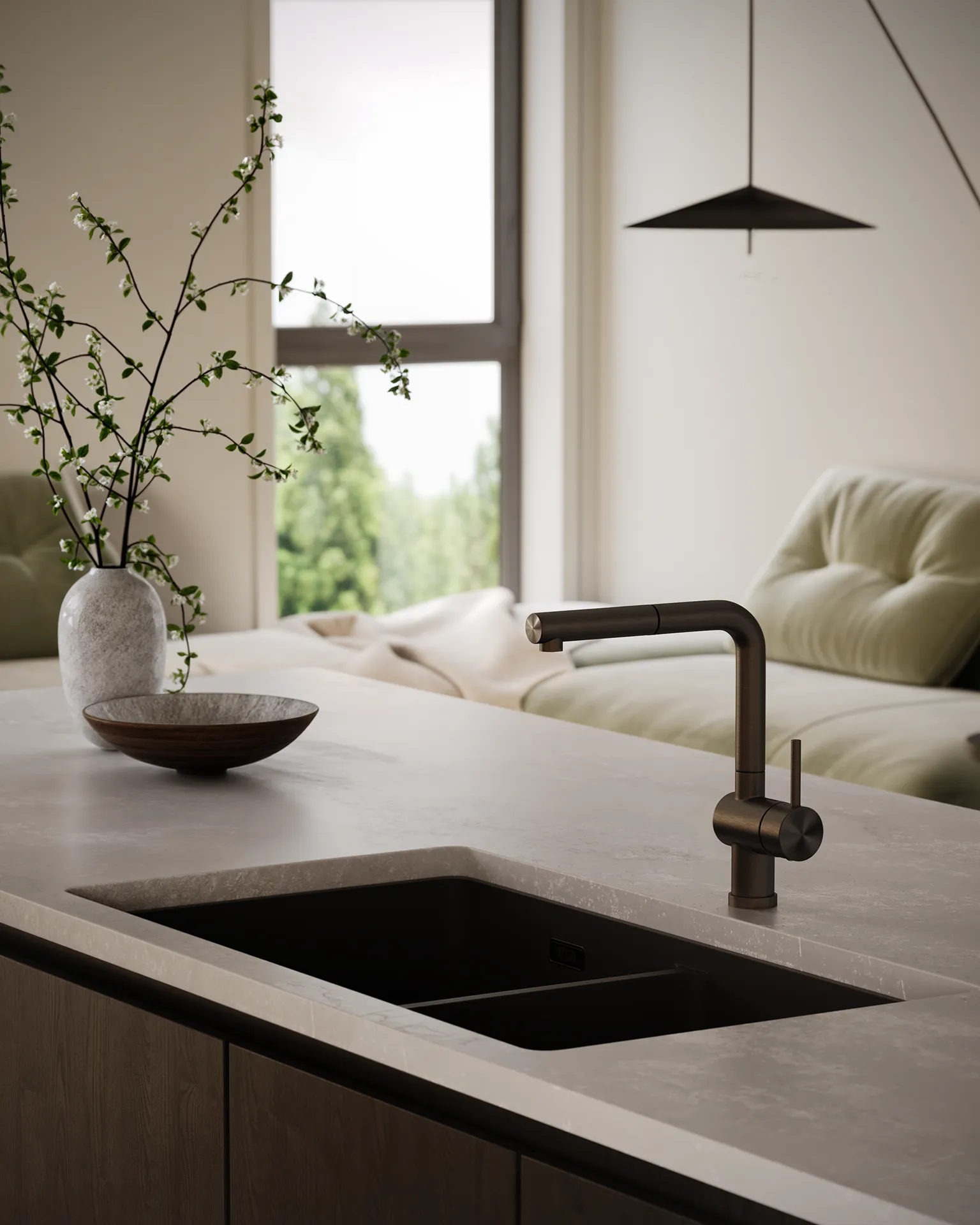 Willa – Close-up rendering of a kitchen island sink with a bronze pull-down faucet and living room visible behind.