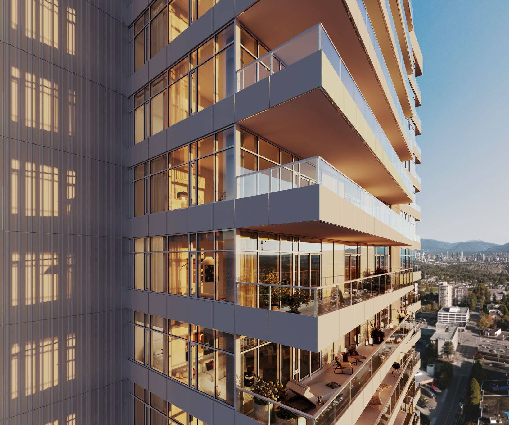 Ethos – An architectural close-up of a modern residential high-rise tower featuring wrap-around glass balconies with warm interior lighting glowing at dusk. The building overlooks a sprawling cityscape stretching toward distant mountain ranges under a clear, late-afternoon sky.