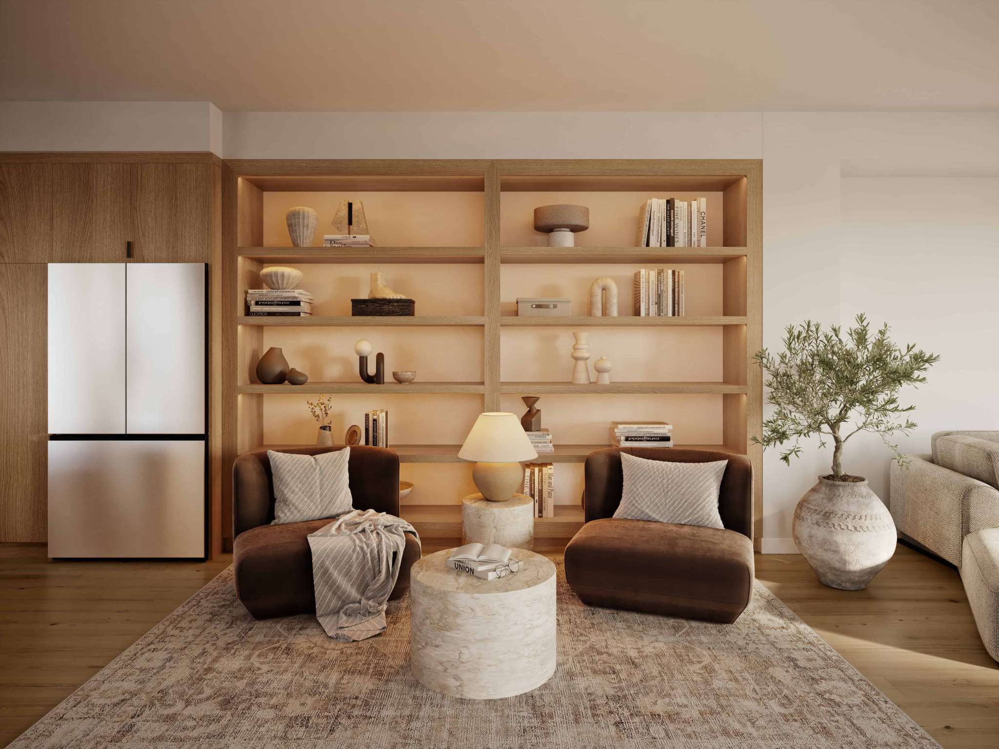 Eden Townhomes – A living area with a built-in wood bookshelf holding decorative objects and books, two brown velvet armchairs, and a stone side table.