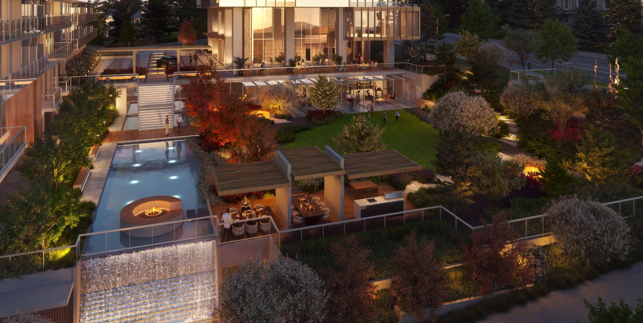Ironwood – An overhead night view of the rooftop amenity deck showing a pool with fire feature, a water wall, pergola-covered dining areas, a lawn, and a gym.