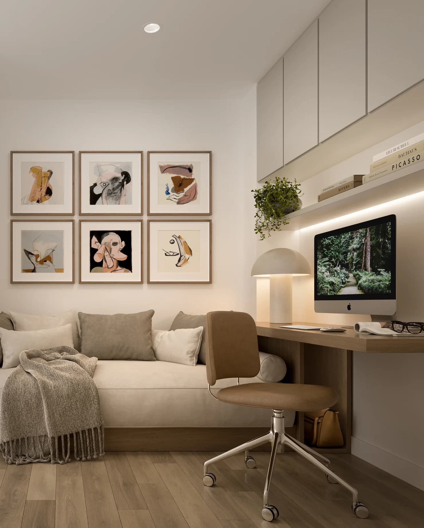 Ironwood – A home office nook with a built-in desk, iMac computer, gallery wall of abstract portrait prints, and an upholstered daybed with cushions.