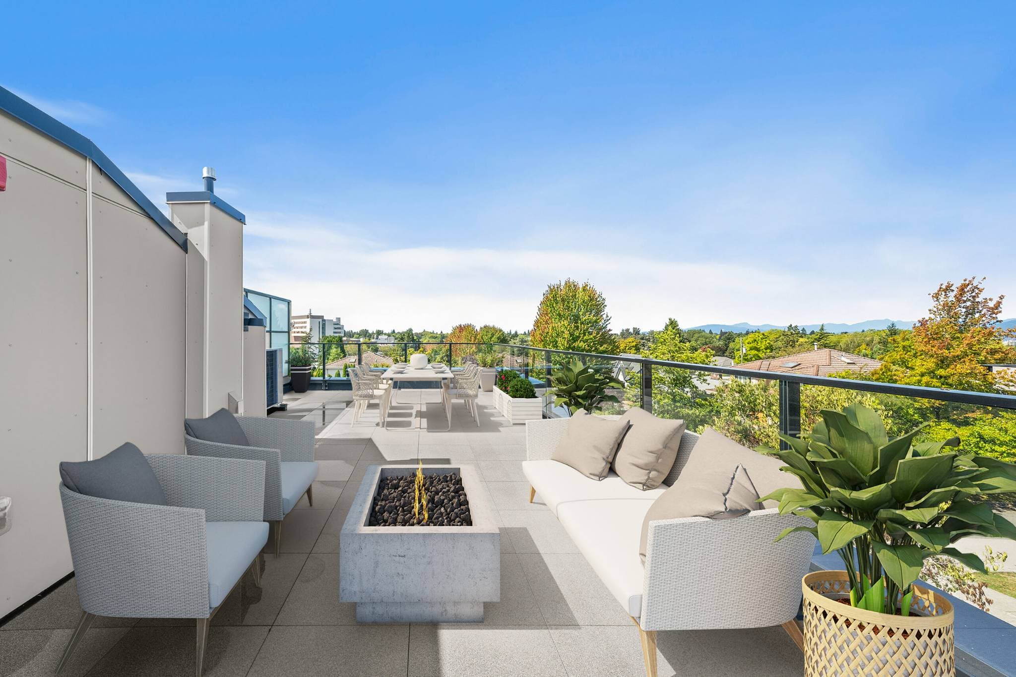 Lilibet – Rooftop terrace with a fire pit table, wicker lounge chairs and sofa, and a dining table for eight, overlooking neighborhood rooftops and distant mountains.