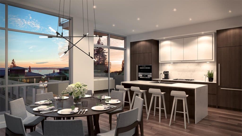 The Peak at Mulgrave Park – Open-concept kitchen and dining area with dark wood cabinetry, a large island with bar stools, and floor-to-ceiling windows showing an ocean sunset view.