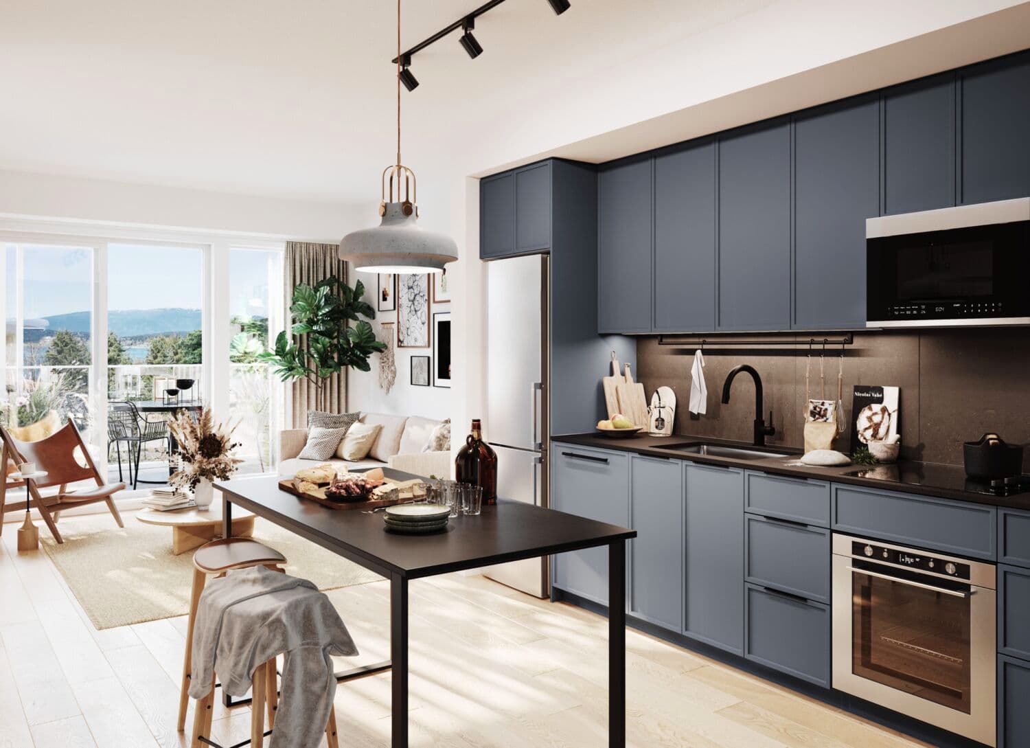 Moody Yards – An open kitchen with navy blue cabinetry and black countertops, a stainless fridge and oven, and a black dining table with stools, opening to a living room with a water and mountain view.