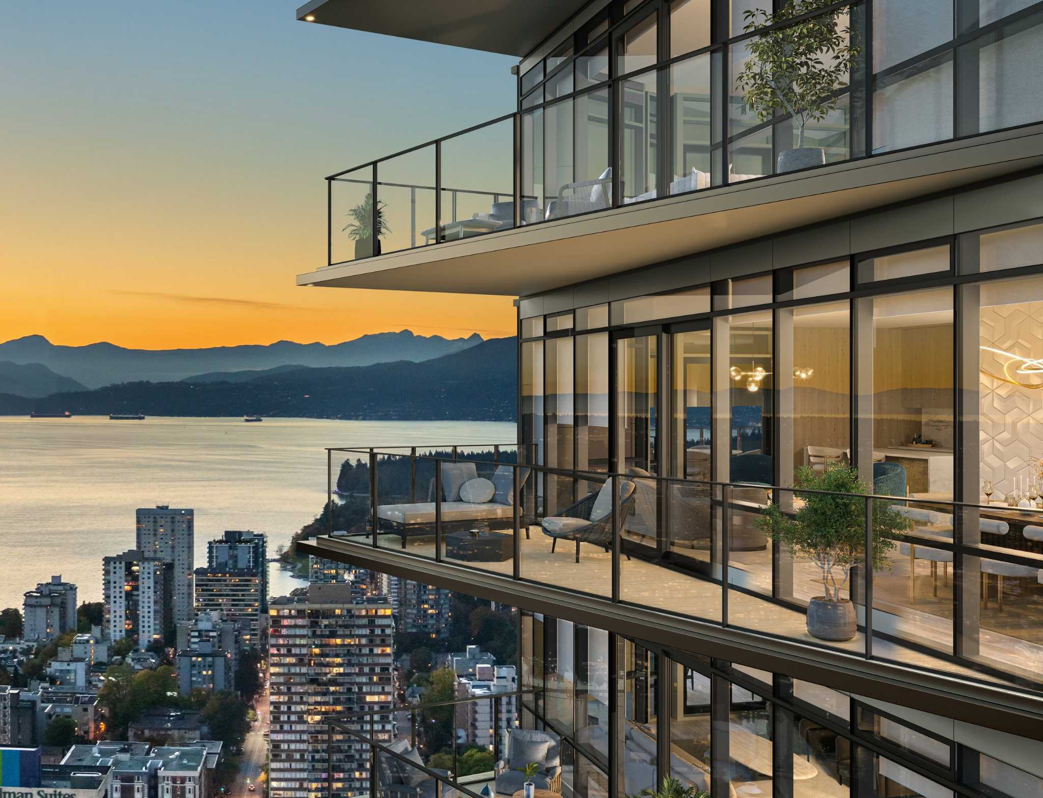 Monogram – A high-rise residential tower features spacious glass-railed balconies and floor-to-ceiling windows overlooking a coastal city at sunset. In the background, calm ocean waters and distant mountain silhouettes are illuminated by a glowing orange and golden sky.