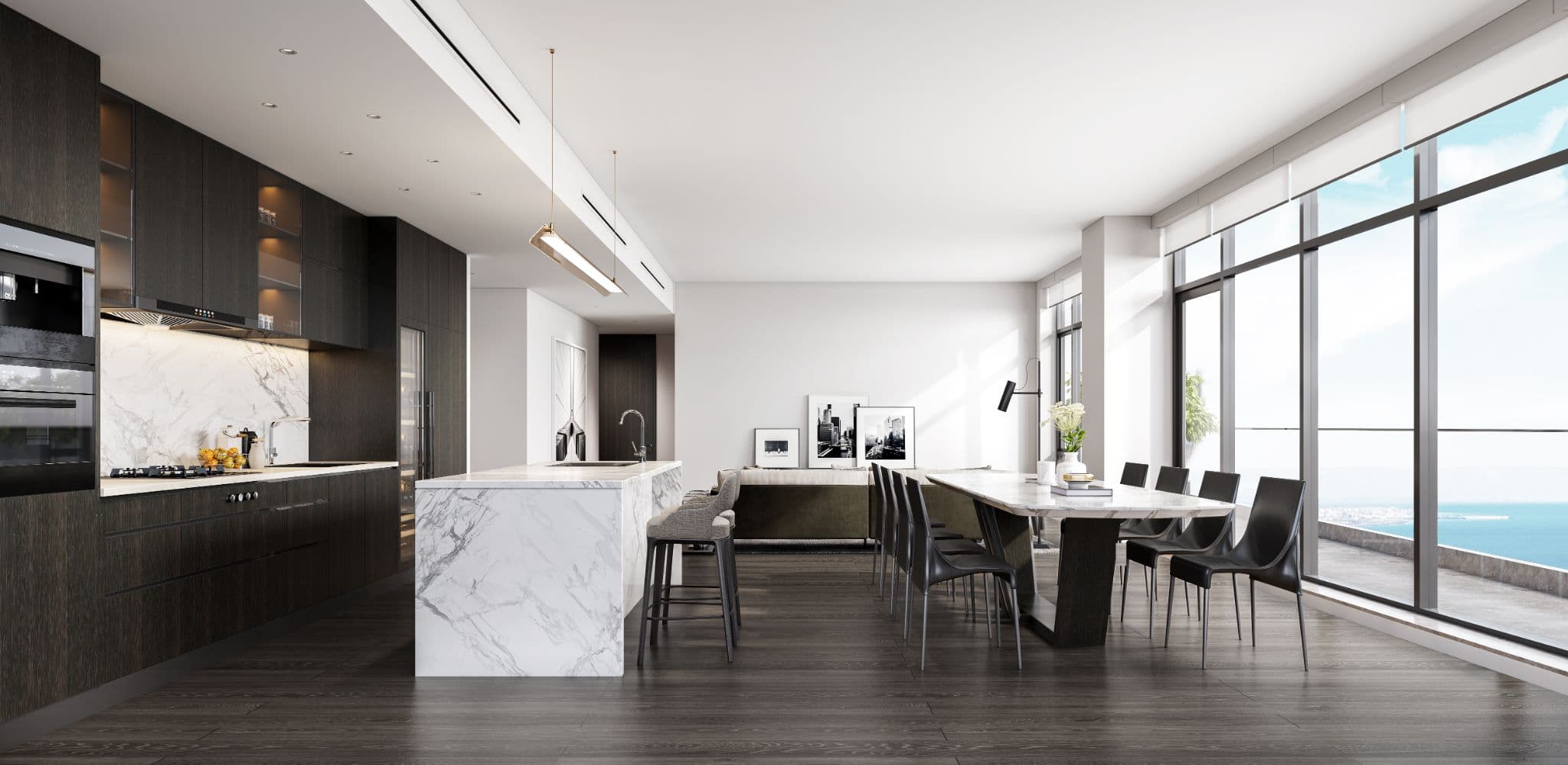 Rodgers Creek One – A bright, modern open-concept kitchen and dining area featuring dark wood cabinetry, a white marble waterfall island, and a long dining table set on dark hardwood floors. Floor-to-ceiling windows fill the space with daylight and offer sweeping views of the open ocean beyond.