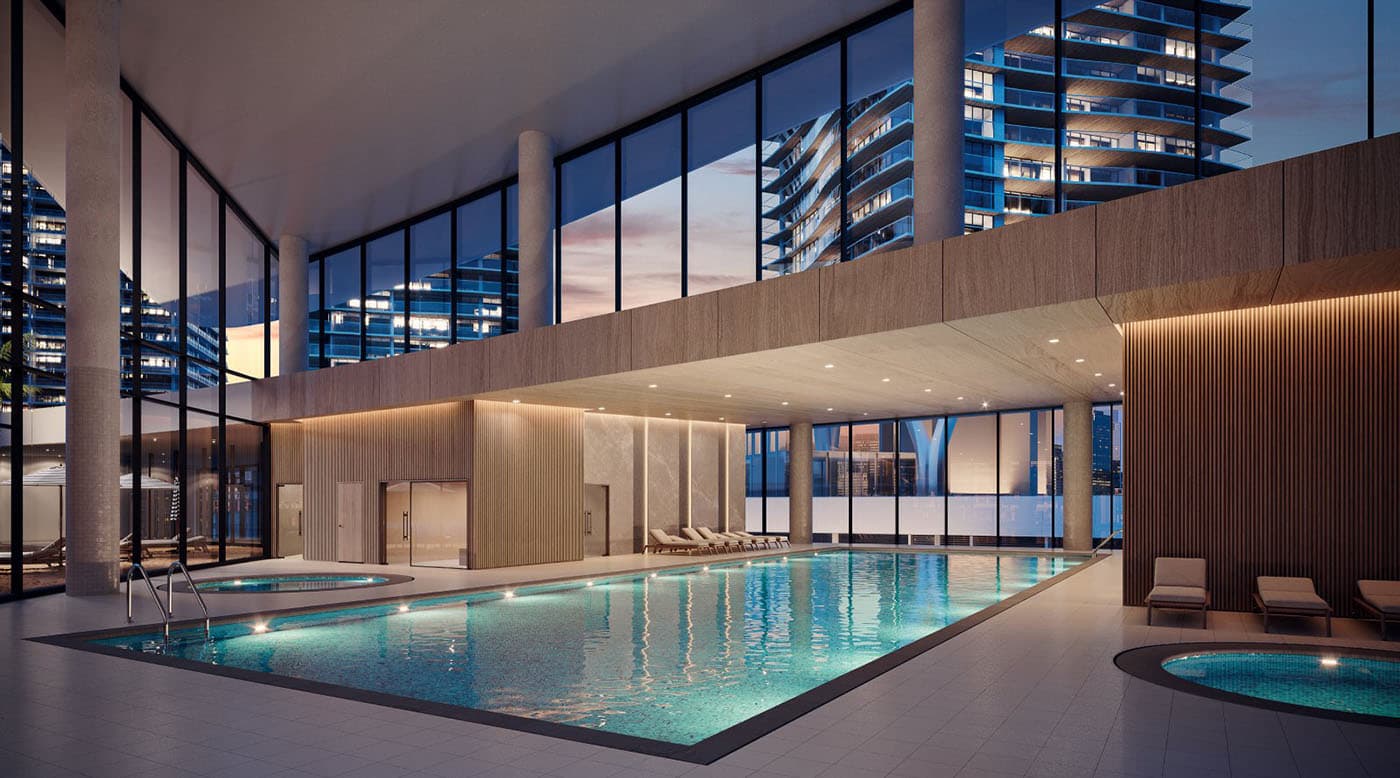 Circle at Concord Brentwood – Rendering of an indoor pool and hot tub lit at dusk, with city towers visible through floor-to-ceiling windows.