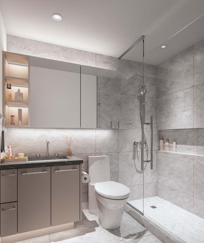 Circle at Concord Brentwood – Bathroom with grey stone-look tile, a glass-enclosed shower, a toilet, and a dark vanity with backlit mirrored shelving.