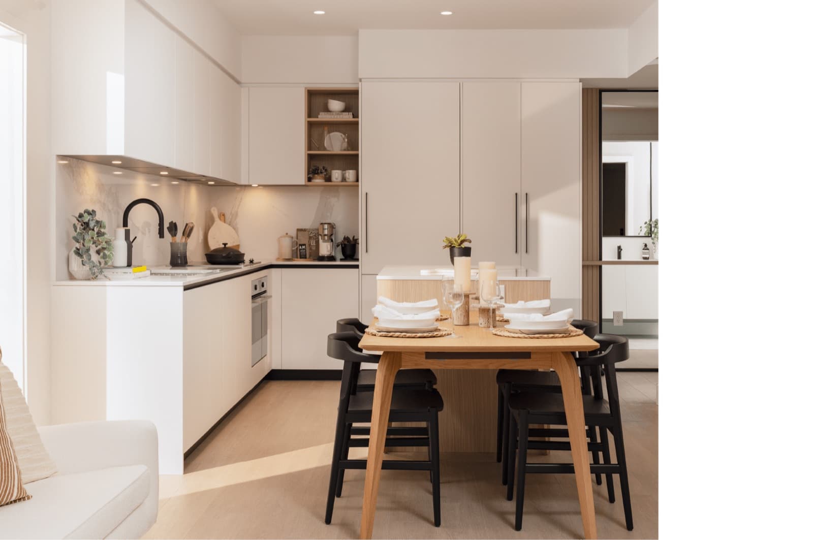 Umbra at Portwood – A bright kitchen and dining space with minimalist white cabinetry, built-in shelving, and a wooden dining table set for six.