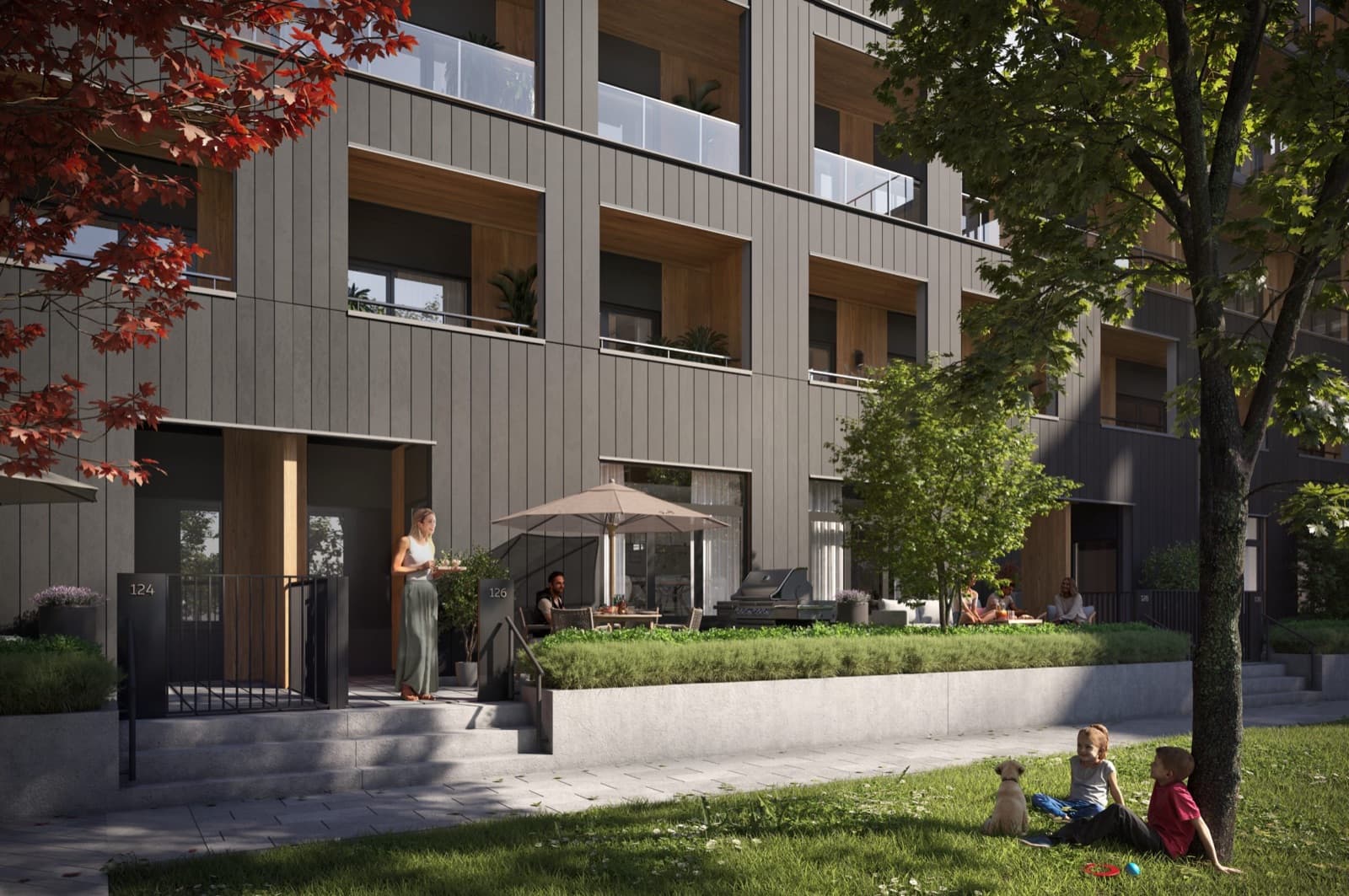 Umbra at Portwood – Street-level view of the modern dark grey building facade featuring ground-floor patio entrances and lush landscaping.