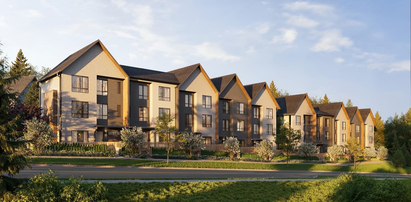 Towns at Burke – Row of three-story townhomes with gabled rooflines in tan, gray, and wood-tone siding, set against a backdrop of evergreen trees.