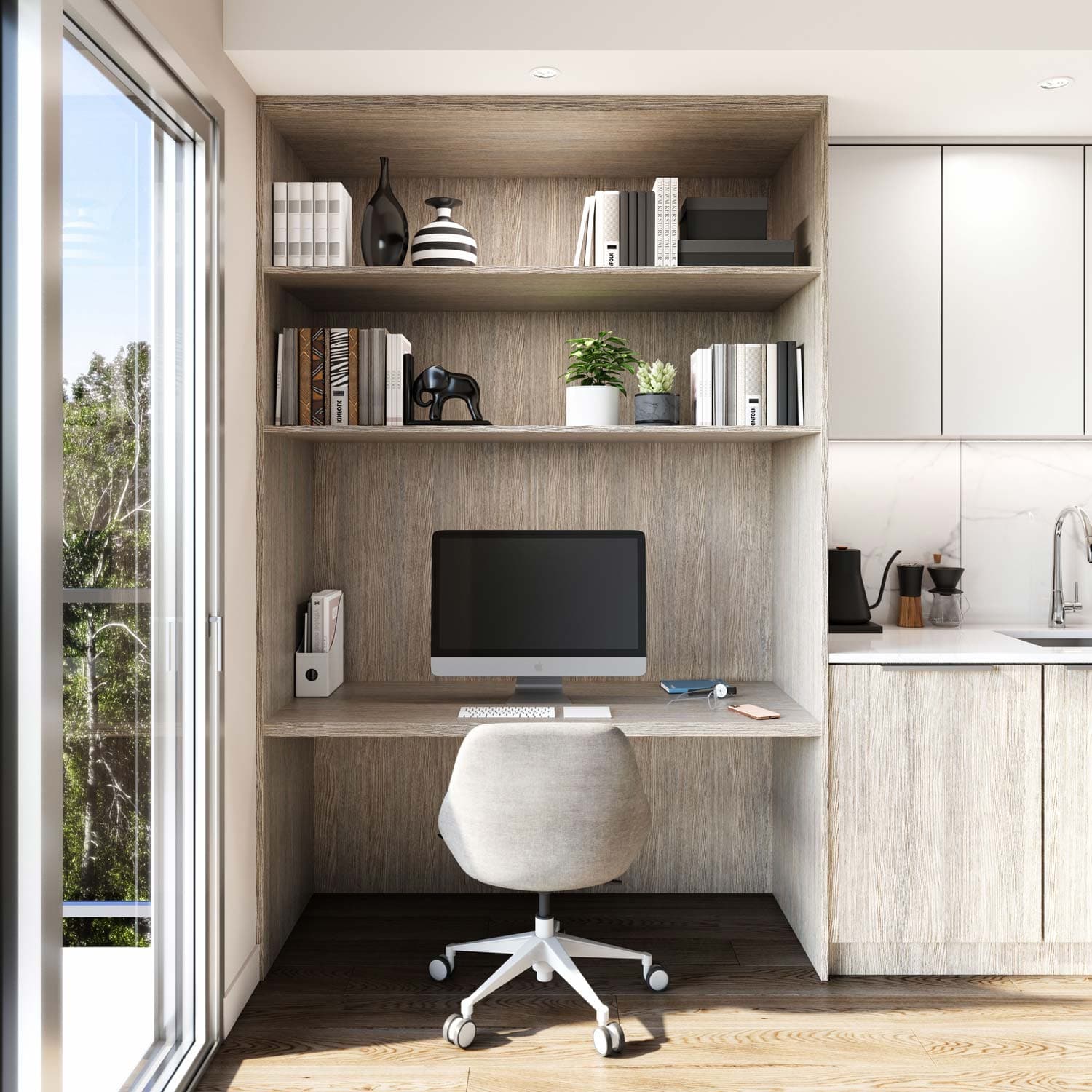 Sitka House – Built-in home office nook with open wood shelving holding books and decor, a desk with a computer monitor, next to a kitchen counter.