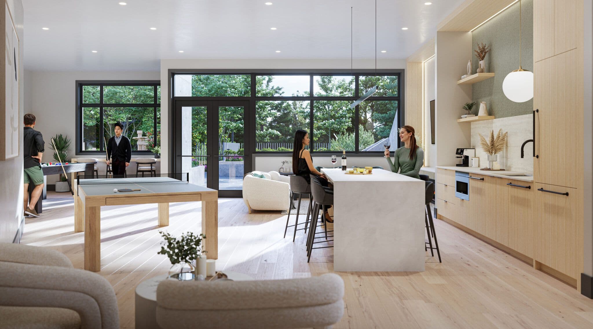 Emerald – A bright, multi-functional resident lounge featuring a ping-pong table, pool table, and a modern kitchen island where people gather with wine. Large floor-to-ceiling windows and glass doors look out onto lush outdoor greenery, filling the wood-accented space with daylight.