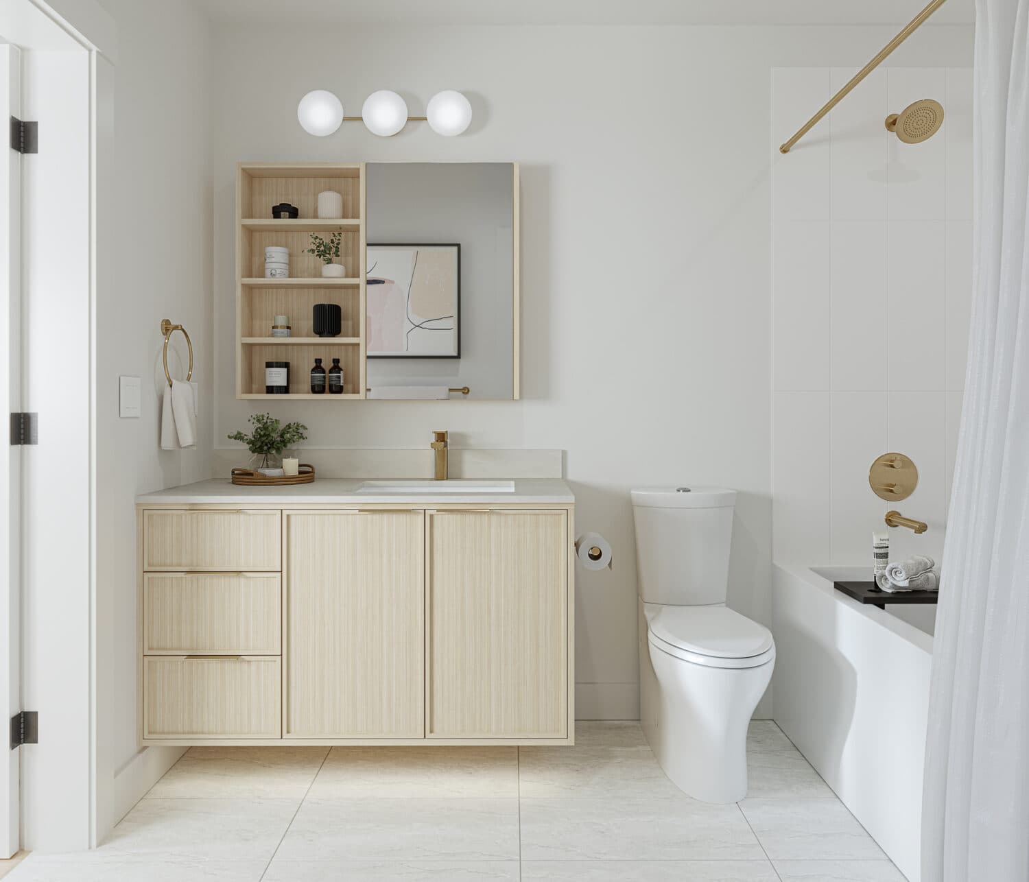 Emerald – A modern bathroom featuring light wood floating vanity cabinets, brush gold hardware, a mirror with integrated side shelving, and a toilet next to a tiled shower tub combo. Bright overhead orb lighting and off-white tile floors create a clean, minimalist aesthetic.