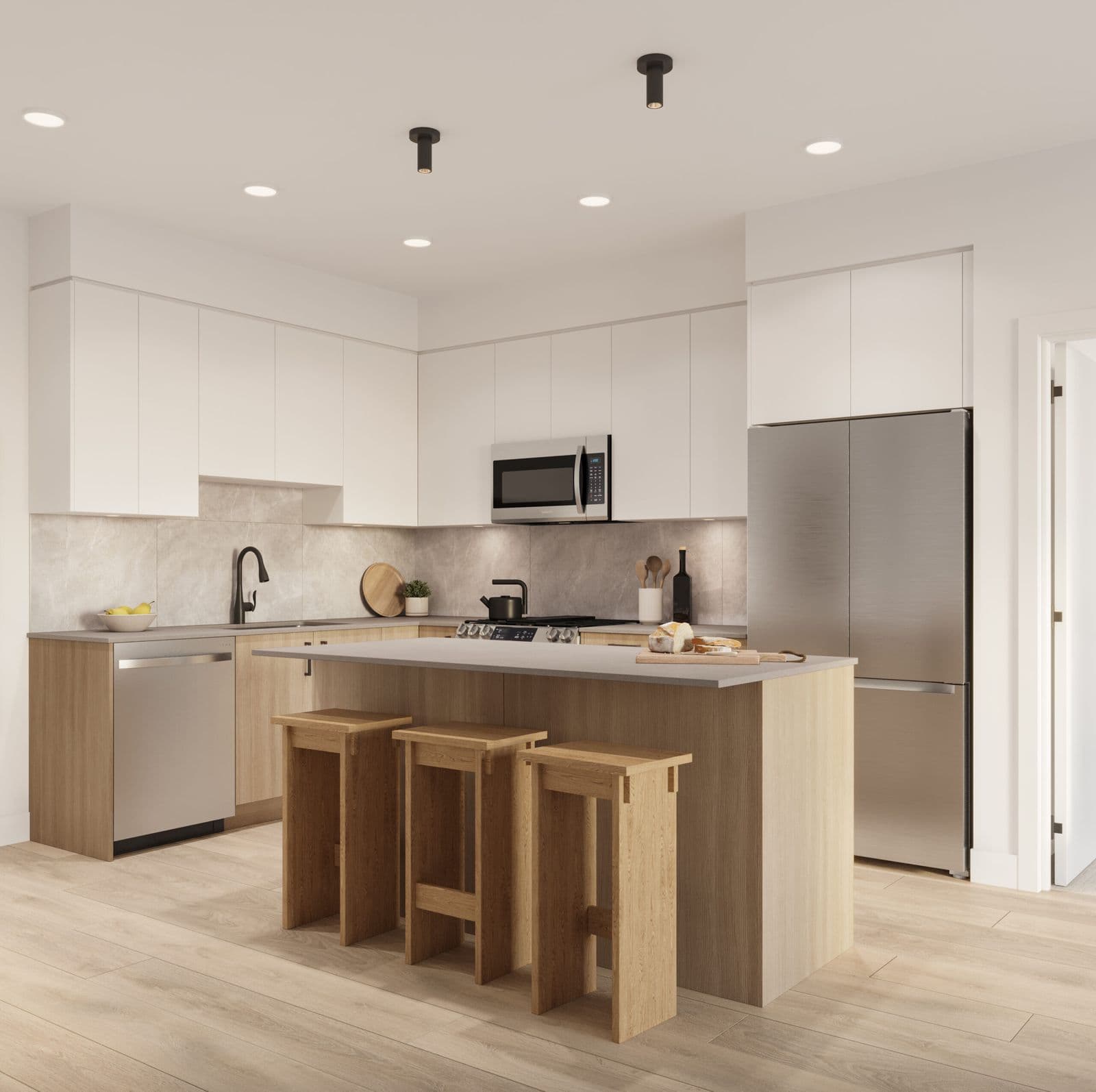 The Commons – Kitchen with white upper cabinets, light wood lower cabinets, a stainless steel fridge, stove, and microwave, and a wood island with three bar stools.