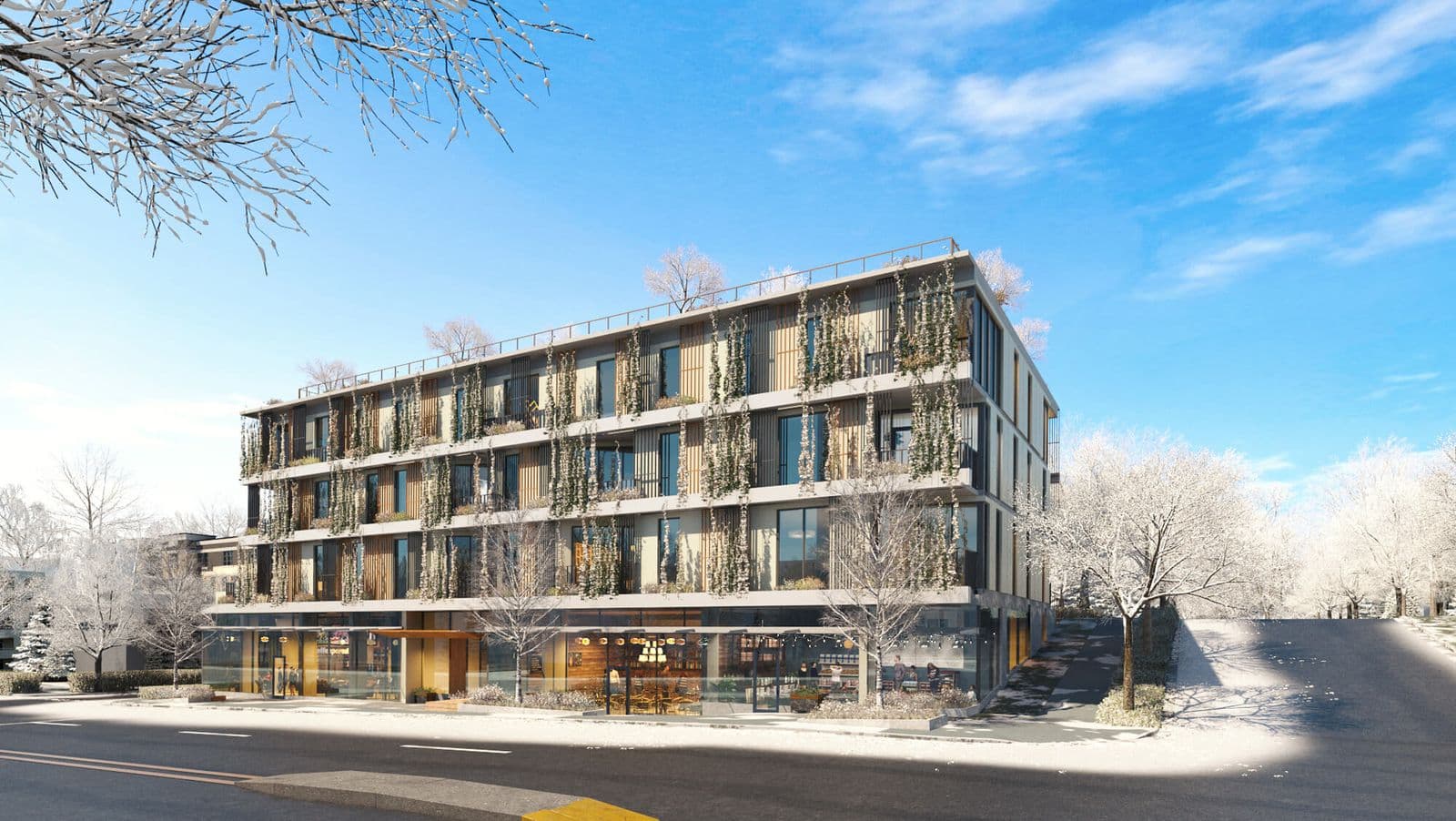 The Arbutus – Winter street-level view of the building's facade with wood slat balconies, climbing vines, and ground-floor retail storefronts, snow-covered trees in front.