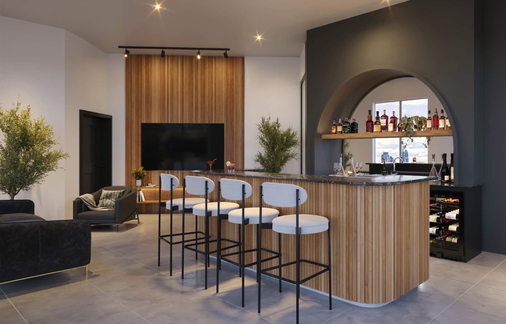 Stowa – A modern resident lounge featuring a wood-slatted wet bar with counter seating, a dark arched accent wall, and a built-in wine fridge. The adjoining entertainment area displays a wall-mounted TV framed by vertical wooden paneling, comfortable dark armchairs, and lush indoor plants under warm ceiling lights.