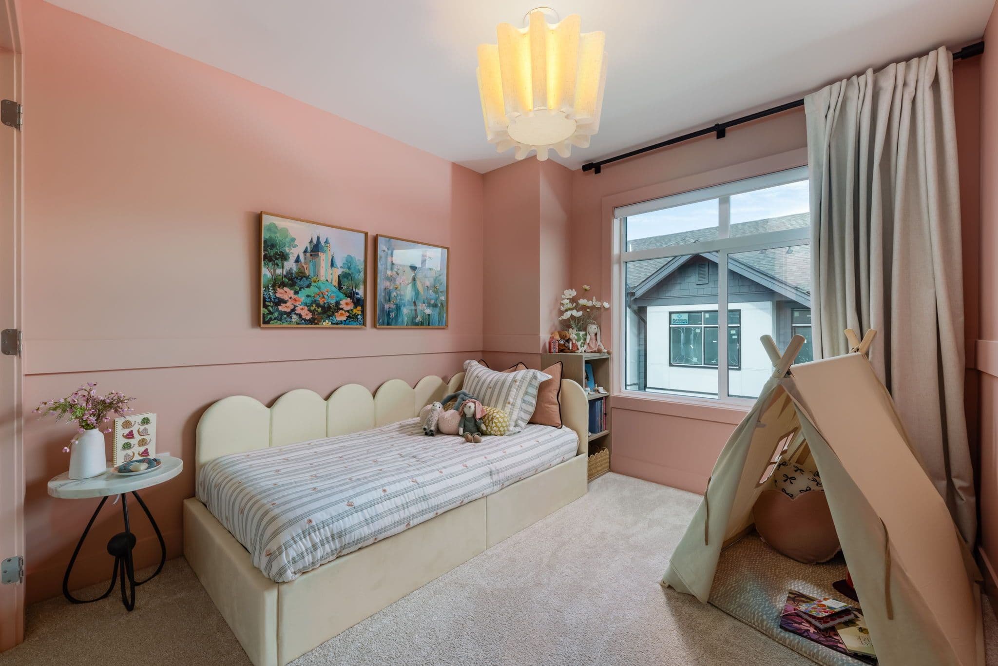 Charlton – Child's bedroom with pink walls, a scalloped cream daybed with striped bedding and stuffed animals, and a canvas play tent.