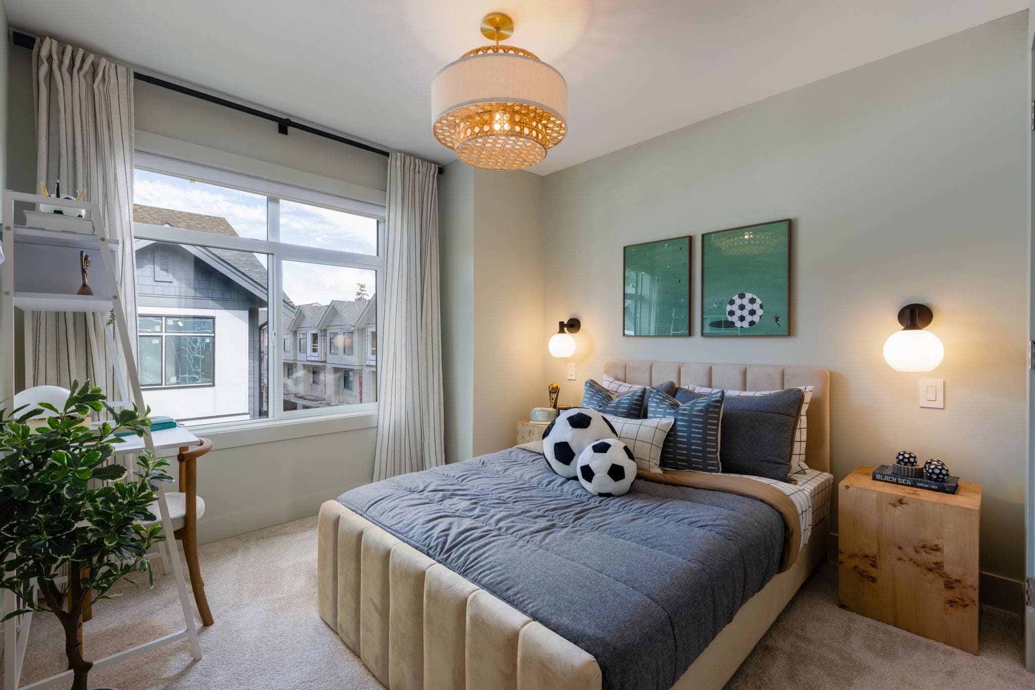 Charlton – Kid's bedroom with sage green walls, a beige channel-tufted bed with soccer-themed bedding and pillows, and green soccer-print art.