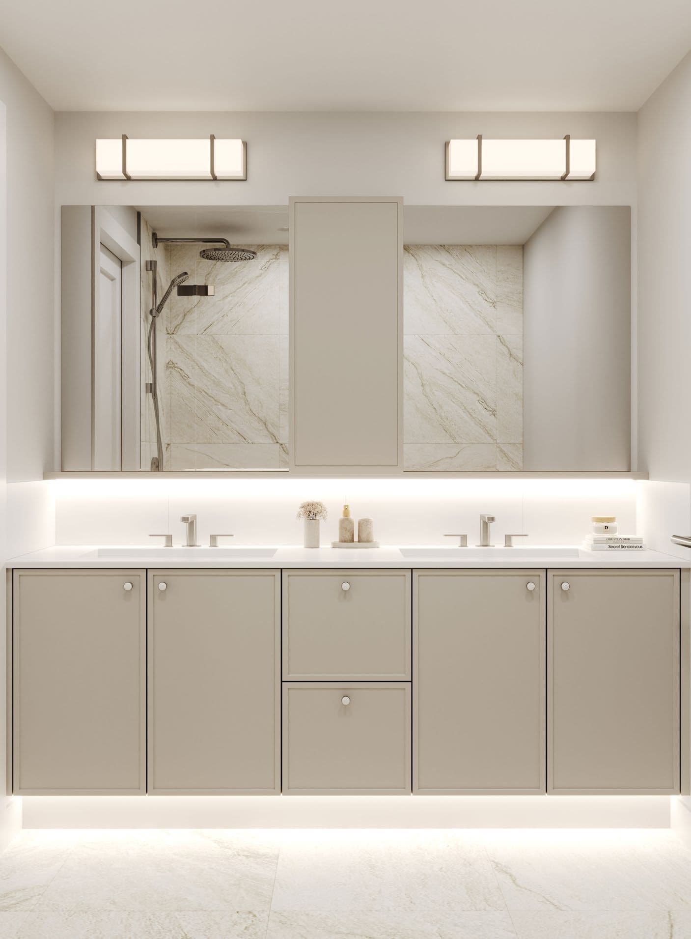 Westview Townhomes – A modern, neutral-toned bathroom vanity featuring a double-sink counter with matte beige cabinetry and silver hardware under warm ambient lighting. A large multi-panel mirror with a central cabinet reflects an elegant walk-in shower lined with marble-patterned wall tiles.