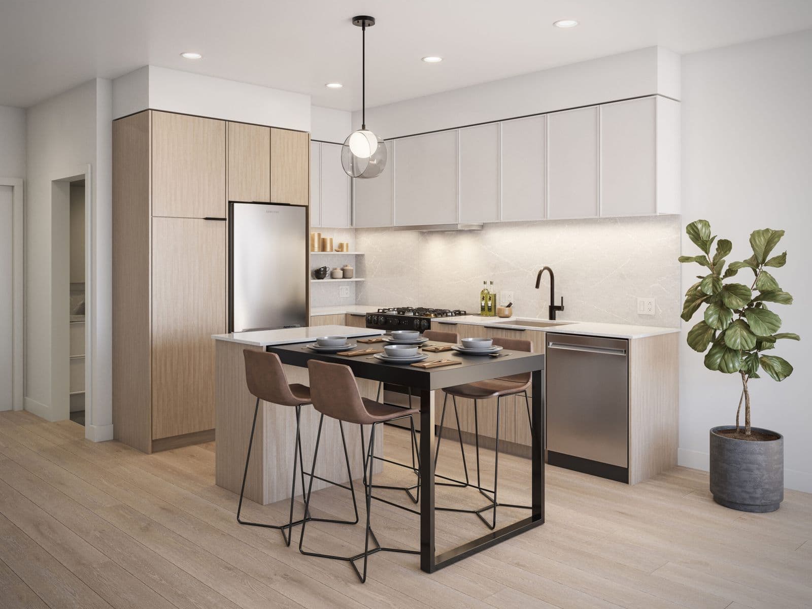 Spera – Modern kitchen with light wood cabinetry, a stainless fridge, pendant light over an island dining table with bar stools, and a large potted plant.