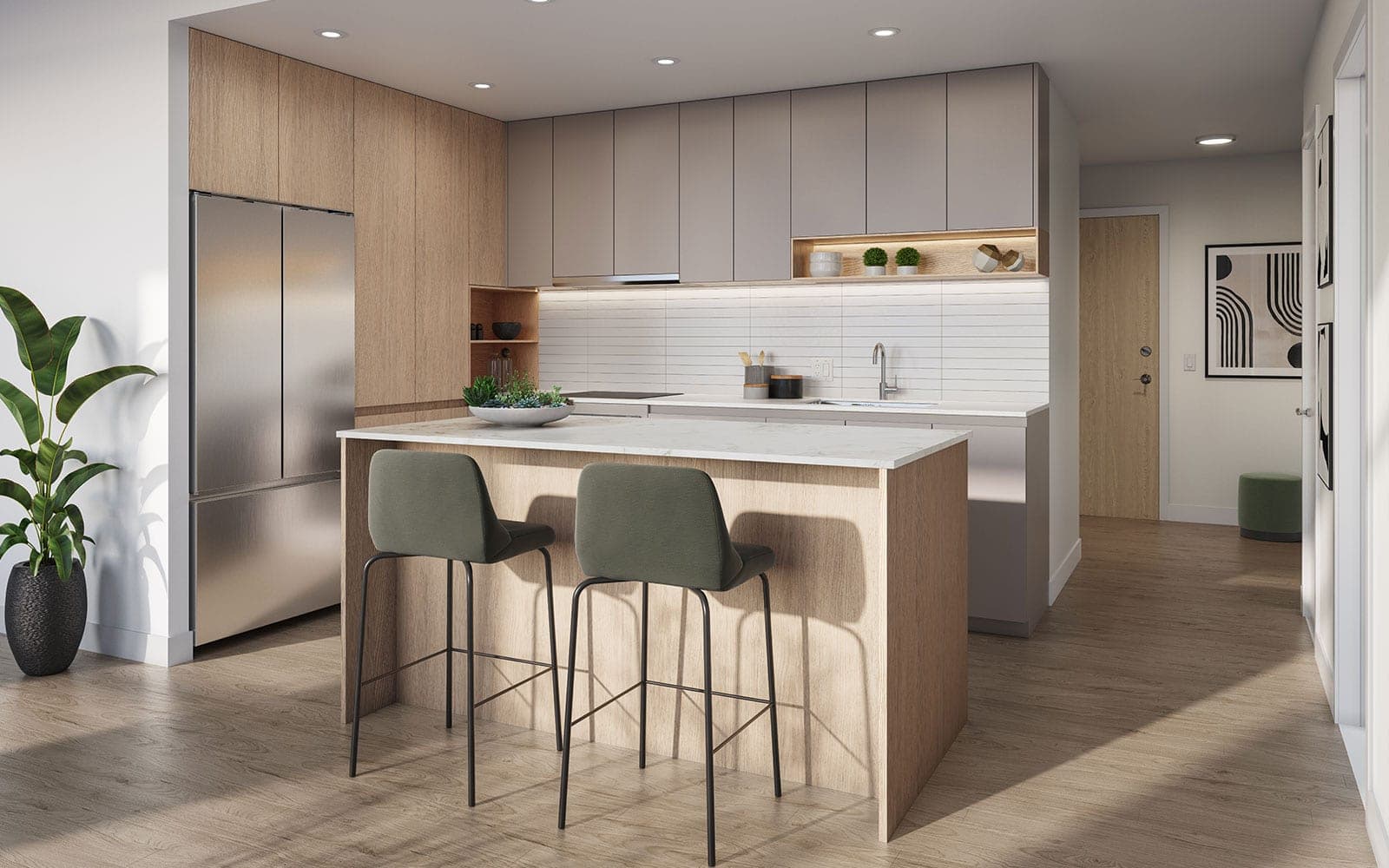 Ashton – A kitchen with wood and grey two-tone cabinetry, a stainless fridge, white stone island with a marble top, and two green upholstered bar stools.