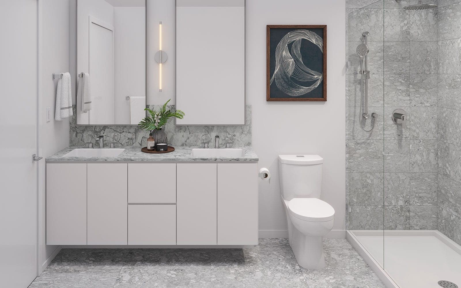 Ashton – A bathroom with a double-sink marble vanity, backlit mirrors, framed art, a toilet, and a glass-enclosed tiled shower with a rain head.