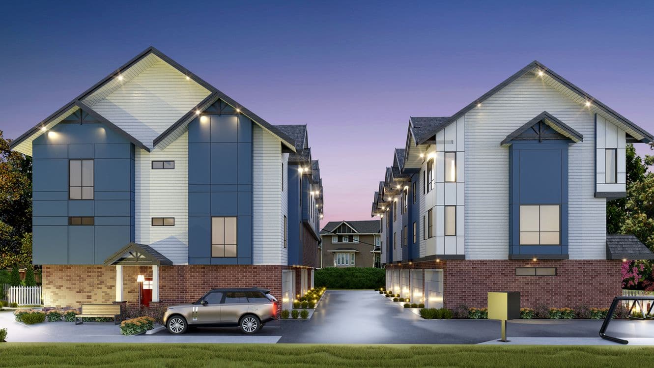 Clove – An architectural rendering of a multi-unit townhouse complex at twilight, featuring pitched gables, blue paneling, white horizontal siding, and red brick bases. A central paved driveway leads between the two rows of homes, illuminated by exterior soffit and ground lighting, with an SUV parked in front.