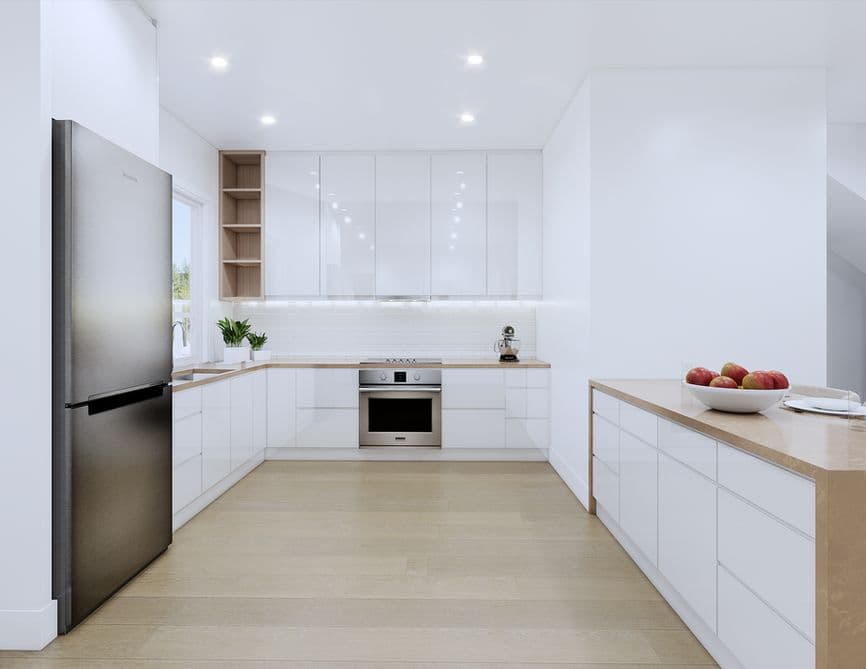Clove – A bright, minimalist modern kitchen featuring glossy white flat-panel cabinetry, light wood-look countertops, and light wood flooring. A stainless steel refrigerator stands in the foreground opposite an island counter, with an integrated oven and cooktop set against a white tiled backsplash beneath recessed ceiling lights.