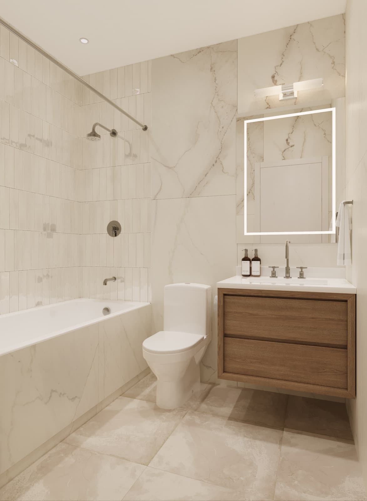 Compass Cohousing – Bathroom with marble-look tile walls, a floating wood vanity with a backlit mirror, a soaker tub with shower, and a wall-mounted toilet.