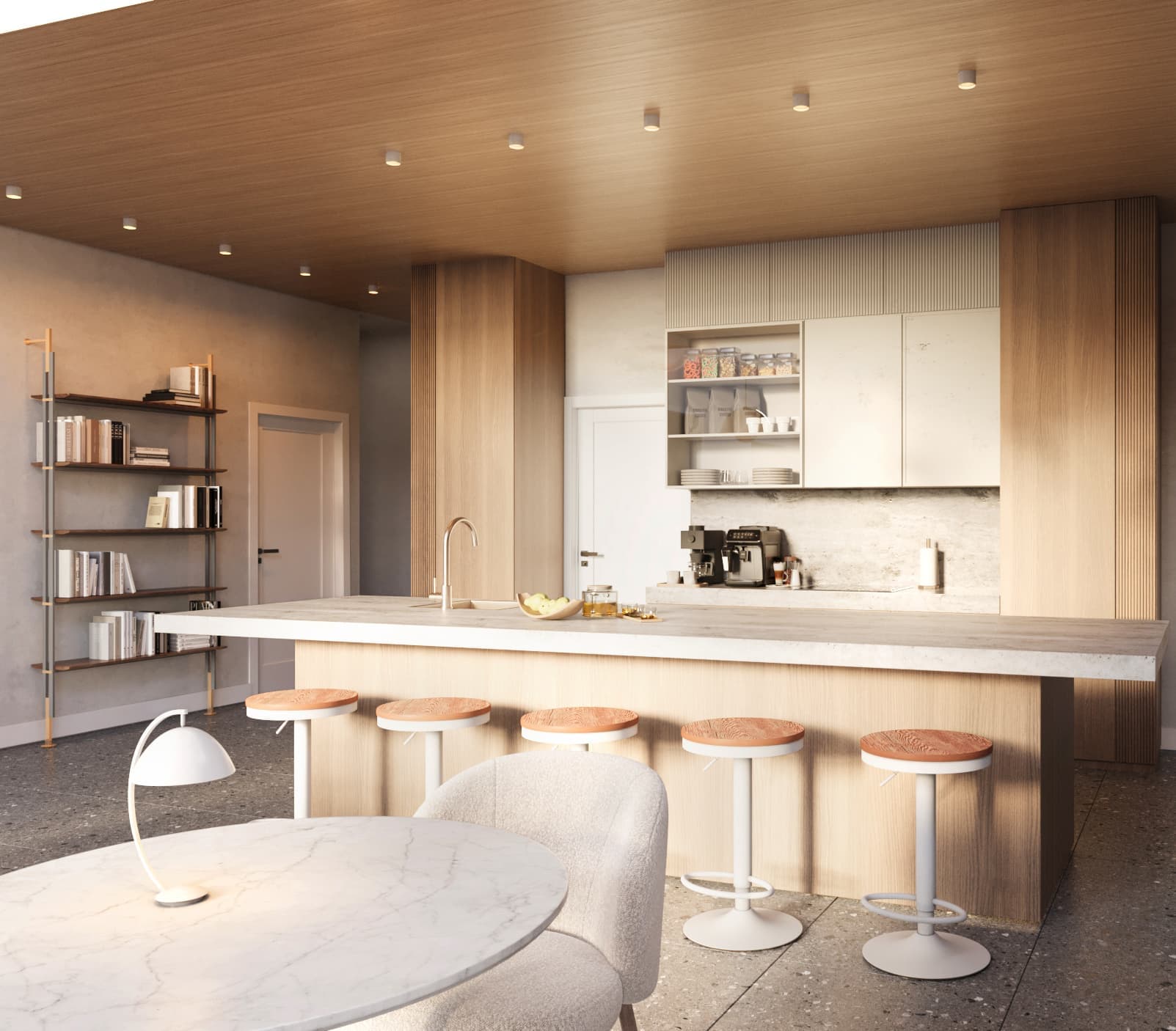 Compass Cohousing – Shared communal kitchen and dining lounge with a long wood island, terracotta-topped bar stools, a marble bistro table, and a wall bookshelf.