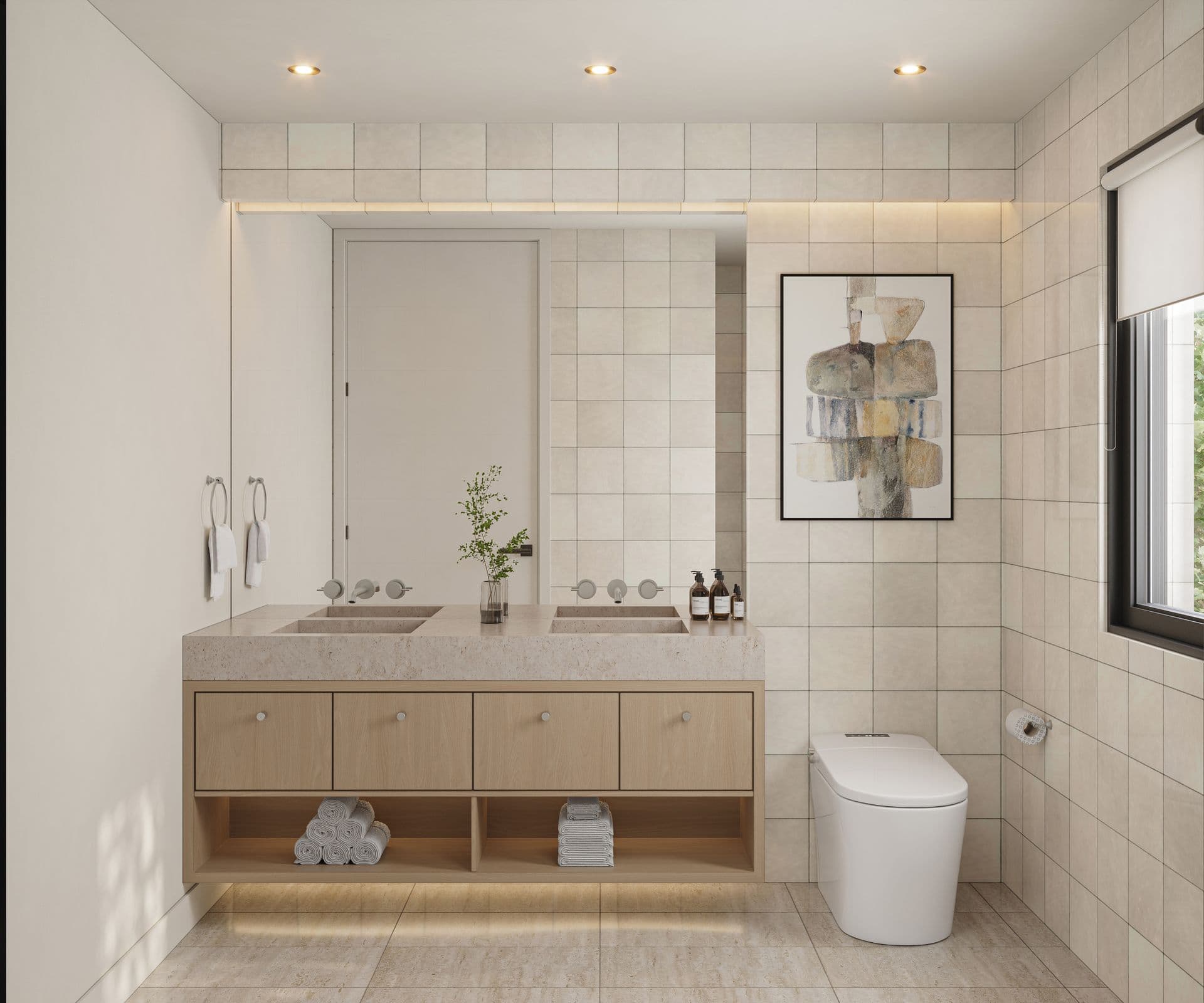 The Park Residences – A modern, bright bathroom featuring a light wood floating vanity with integrated double stone sinks beneath a large frameless mirror. Neutral square tile walls, a sleek modern toilet, warm recessed lighting, and framed abstract art complete the serene, contemporary aesthetic.