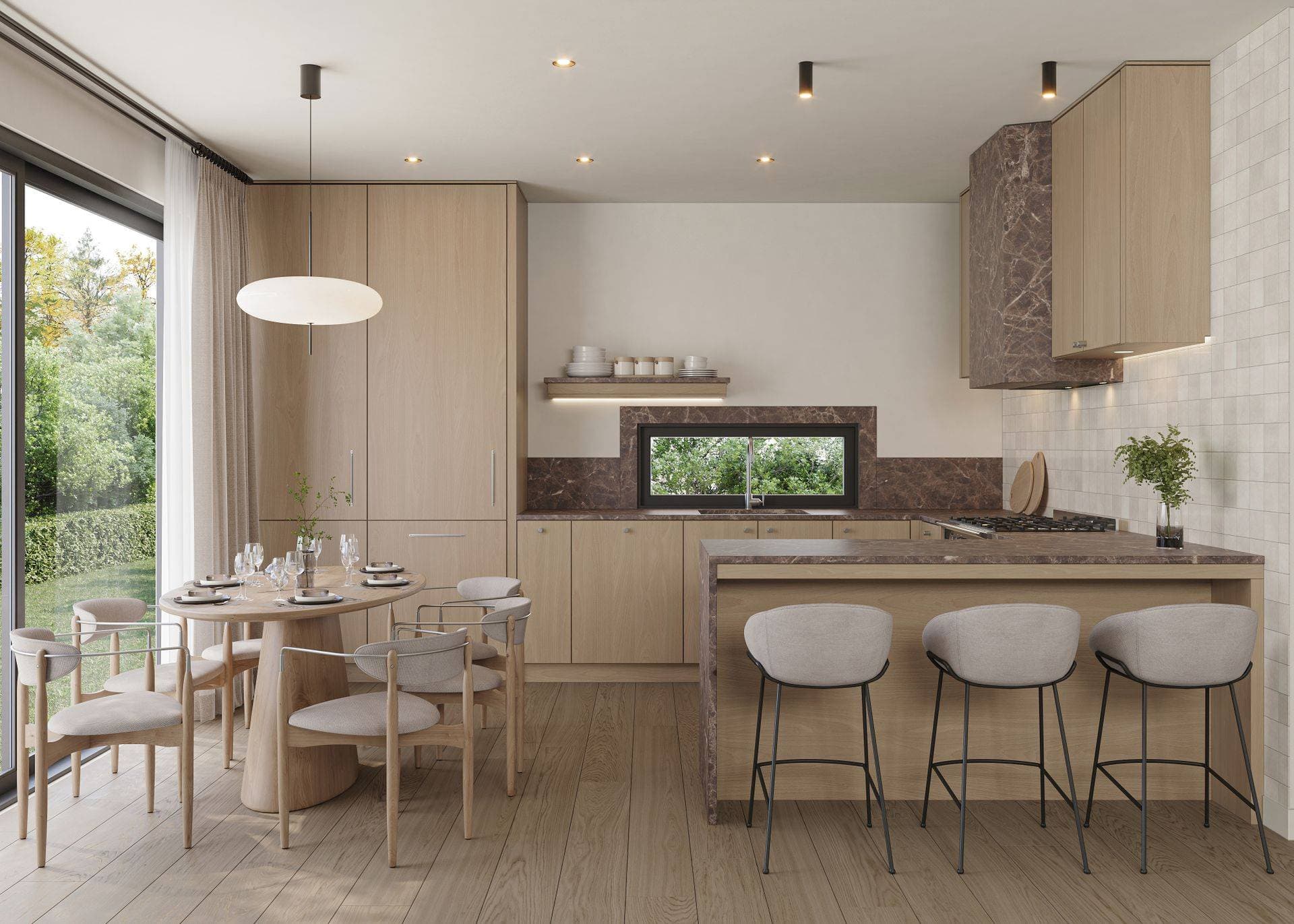 The Park Residences – A modern open-concept kitchen and dining area featuring light wood cabinetry, brown marble countertops and range hood, and a kitchen island with barstools. Next to the island sits a round wooden dining table with chairs, illuminated by bright daylight coming through large glass sliding doors that open onto a lush green garden.