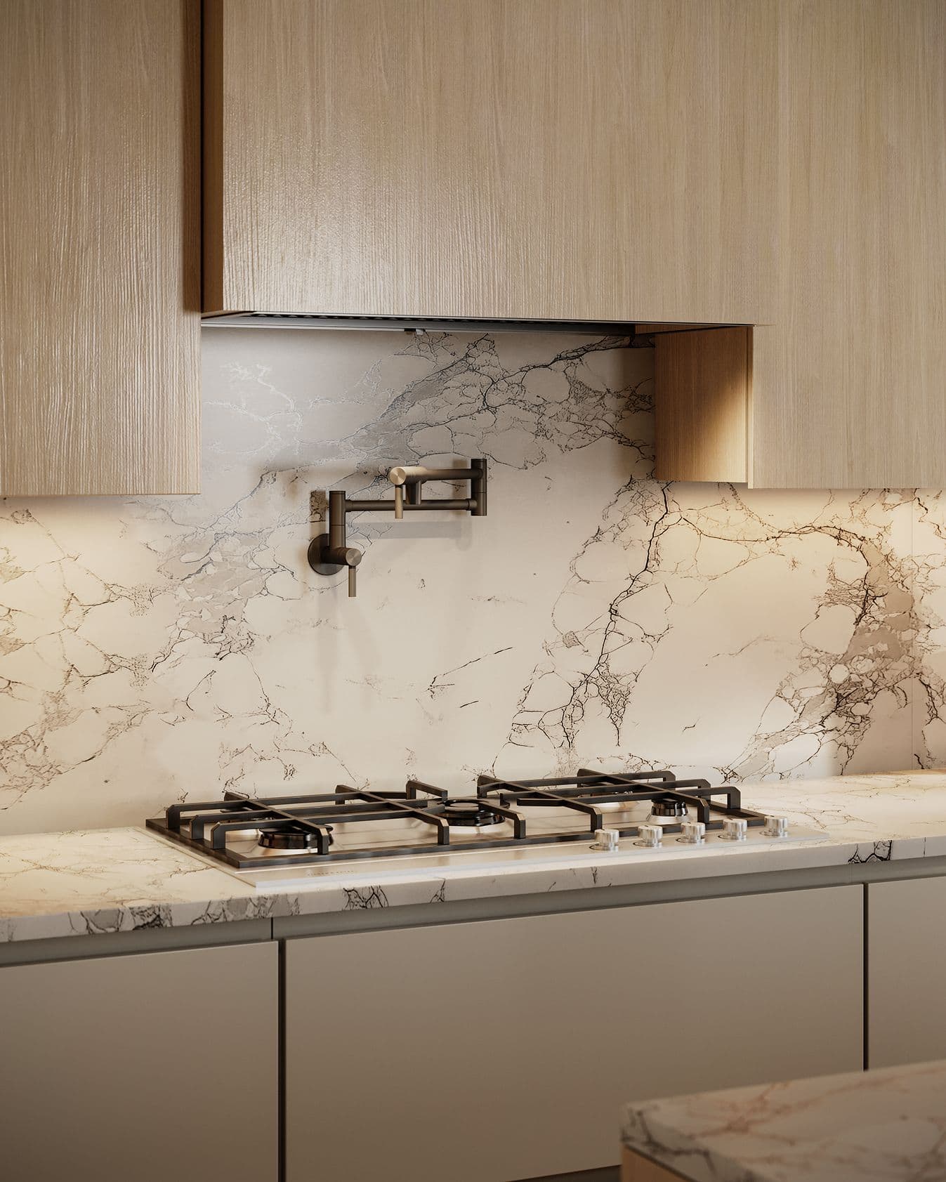 Solin – A close-up shot of a modern kitchen cooking area featuring a drop-in gas cooktop built into a dramatic white-and-grey veined marble countertop and matching full-height backsplash. A matte black wall-mounted pot filler faucet extends above the stove, framed by light natural wood upper cabinetry with warm integrated under-cabinet lighting.