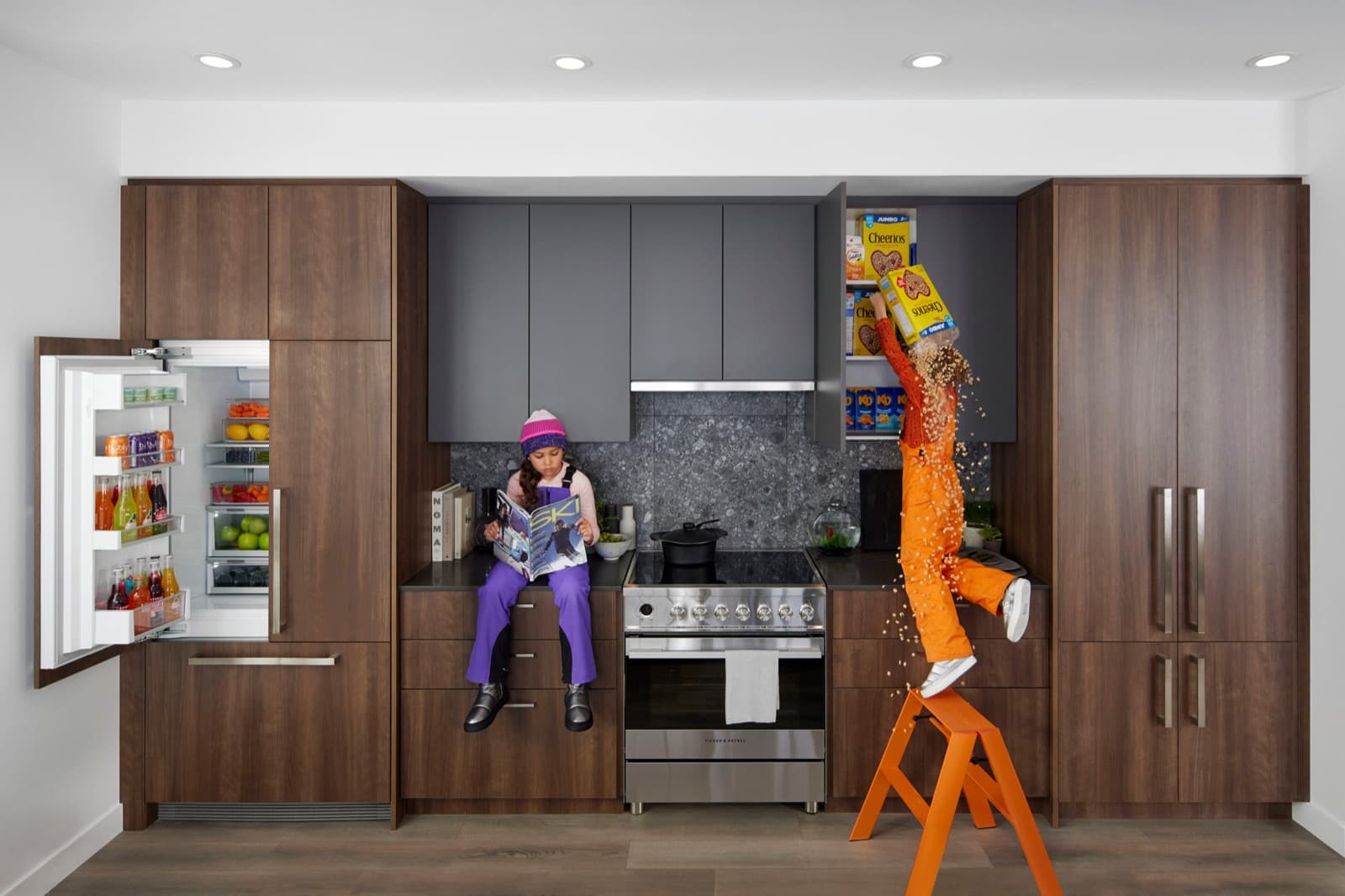 Towns at Lynn – Kitchen with a walnut cabinet wall, open refrigerator stocked with drinks, and two children in a playful staged scene with cereal boxes.