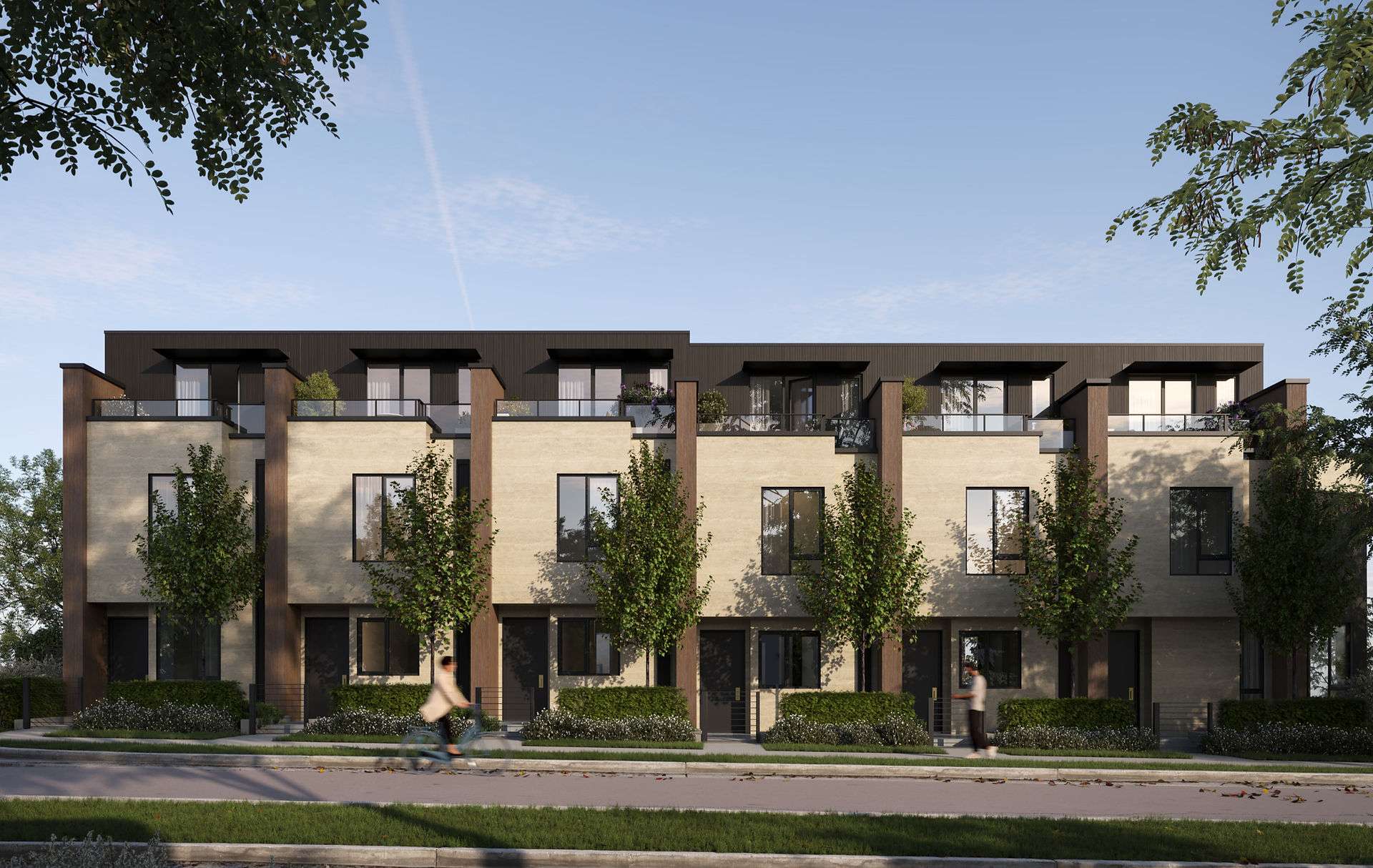 Park & Granville – A row of modern three-story townhomes features light brick facades, dark vertical accents, black-framed windows, and private upper-level terraces with glass railings. Street-level landscaping includes manicured hedges, young deciduous trees, and a paved sidewalk where pedestrians and a cyclist are passing by under a bright blue sky.