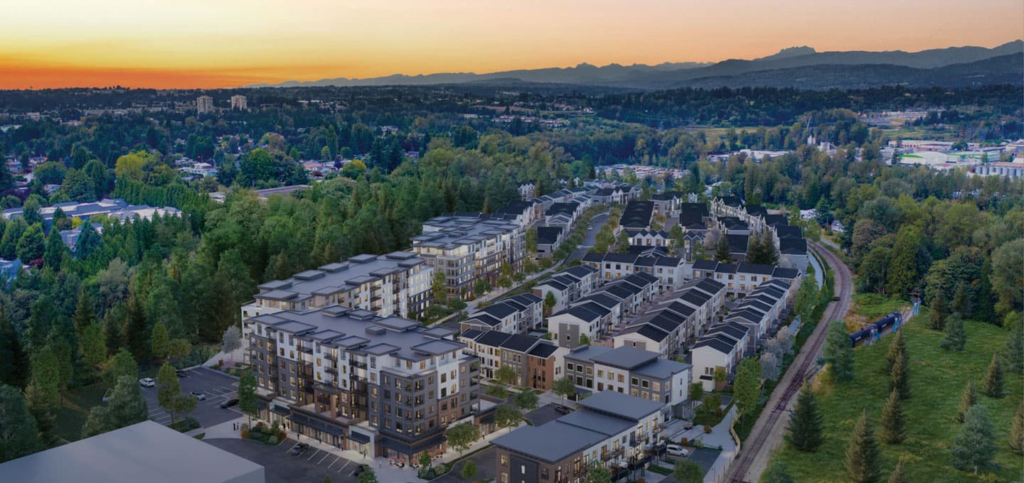 The Rail District – Aerial view of the mixed townhome and apartment community at sunset alongside a railway line, with mountains in the distance.