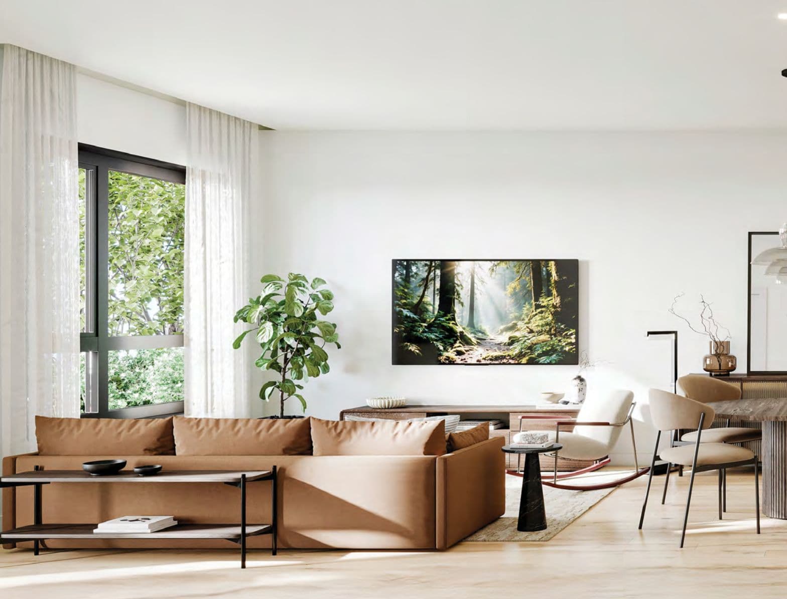 The Edgemont Collection – A living and dining area with a tan sectional sofa, a wall-mounted TV over a wood media console, dining chairs, and large windows with sheer curtains.