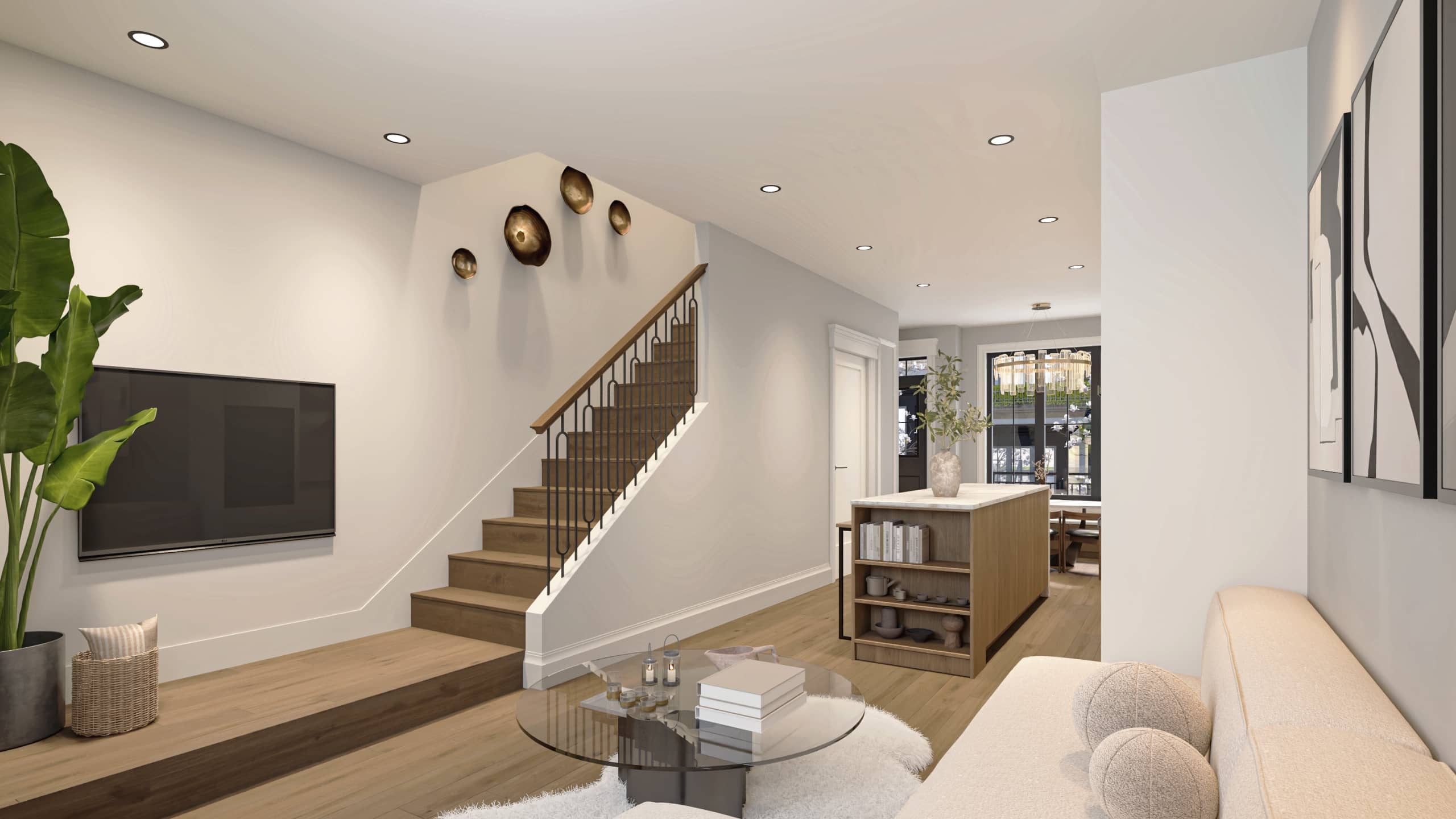 Claremont – A bright, open-concept living space features light wood flooring, a central staircase with wrought-iron balusters, and a glass-topped coffee table in the foreground. In the background, the layout flows into a dining and kitchen area with a wooden island and modern chandelier, all brightly lit with recessed ceiling lights.