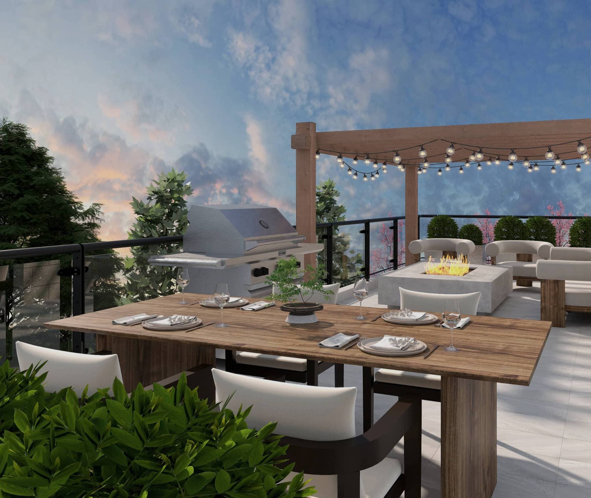 Claremont – A rooftop terrace featuring a set wooden dining table, a stainless-steel BBQ grill, and a modern fire pit lounge area beneath a wooden pergola with string lights. Glass railings enclose the tiled patio, looking out onto treetops against a dusk sky.