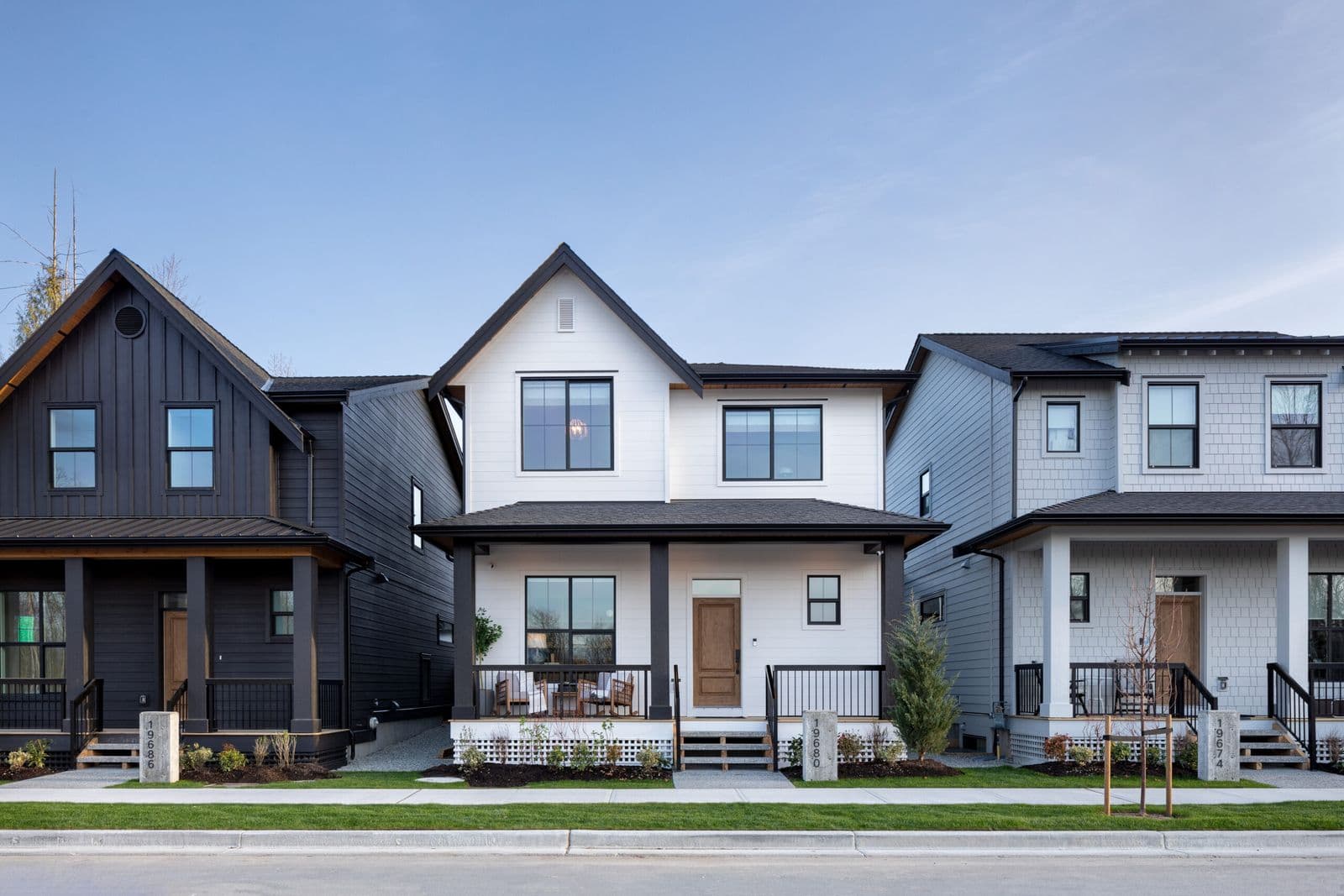 Mirada Estates – Row of modern two-storey single-family homes with gabled roofs, covered front porches, and landscaped front yards along a residential street.