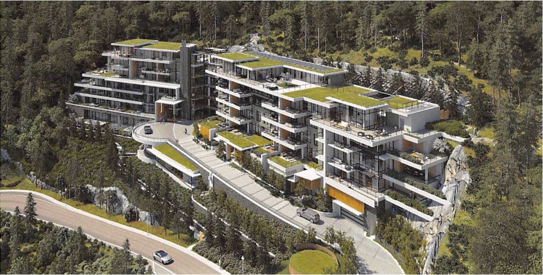 Courtenay at Mulgrave Park – Aerial view of a hillside condo complex nestled in forest with green roof terraces, a circular driveway, and exposed rock outcroppings.
